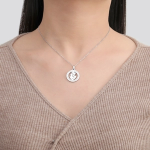 Gros plan d'un collier pendentif mère et enfant sur un modèle avec gravure détaillée