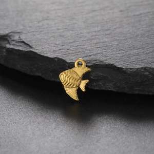 Macro view of gold angelfish pendant with wave texture on dark slate background
