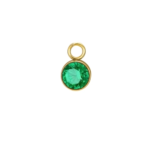 Macro shot of green birthstone charm with gold plating and faceted emerald-cut zircon