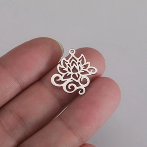 Detalle del colgante de loto de acero inoxidable plateado en la mano para ver el tamaño
