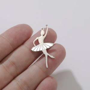 Détail d'un pendentif de ballerine en argent avec émail blanc tenu entre les doigts