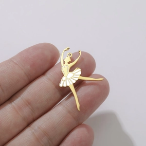 Détail d'un pendentif danseuse de ballet doré avec émail blanc tenu pour la taille