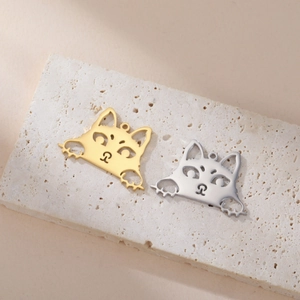Goldene und silberne Katzen-Edelstahlanhänger für DIY-Schmuck auf steinernem Sockel