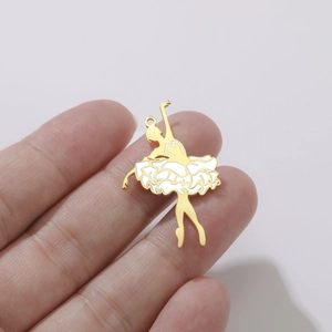 Détail d'un pendentif danseuse de ballet en or et émail blanc sur le bout d'un doigt