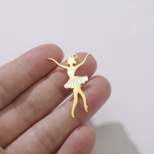 Gros plan d'un pendentif ballerine doré avec émail blanc tenu pour montrer la taille