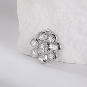 Macro shot of silver stainless steel sunflower pendant with smiling face relief
