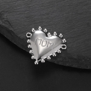 Macro detail van zilveren hartbedeltje met MOM gravure en kralenrand voor DIY sieraden