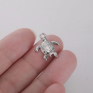 Vue détaillée d'un pendentif tortue en acier inoxydable argenté avec texture de carapace