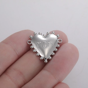 Gedetailleerde macro van een zilveren hartvormige hanger met MOM-gravure voor sieraden