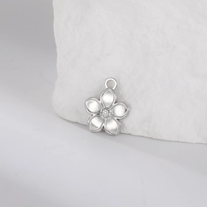 Detailed macro view of a polished silver five-petal flower pendant on a textured stone