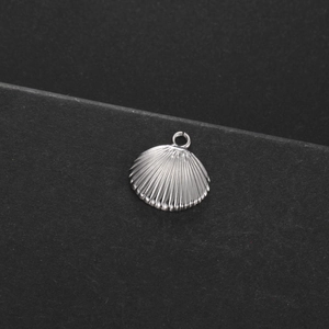 Vue macro détaillée d'un pendentif coquillage argenté avec texture radiale et anneau
