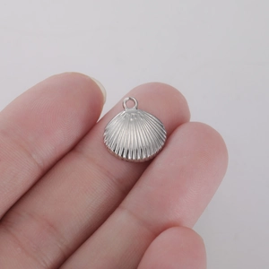 Vue macro d'un petit pendentif coquillage en argent montrant la taille réelle du bijou