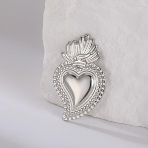 Macro-opname van de zilveren Sacred Heart-hanger met reliëfdetails op een stenen basis