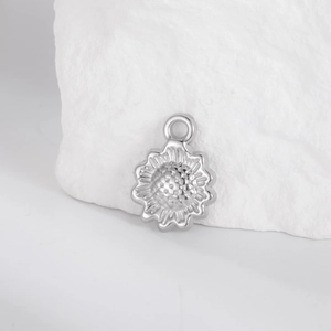 Macro detail of sunflower pendant with embossed texture on minimalist stone background