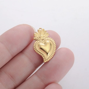 Detailweergave van een gouden 3D-hartvormige hanger vastgehouden voor de maat