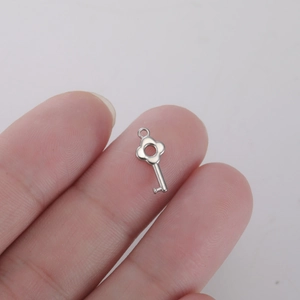 Macro shot of a silver flower-shaped key pendant for DIY jewelry and accessories