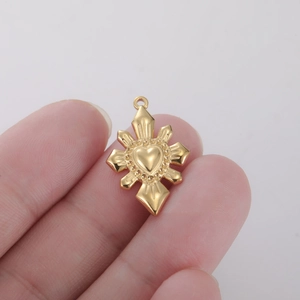Macroshot van een gouden hartvormige hanger met stralende zonnestralen tussen de vingers