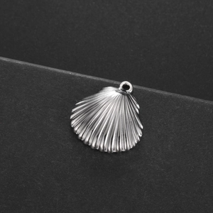 Détail macro d'un pendentif en forme de coquillage argenté avec des textures en relief fin
