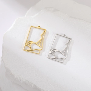 Macro shot of gold and silver rectangular pendants with hollowed female body art outlines