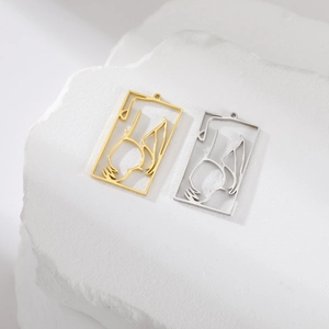 Detail of cutout rectangle pendants in gold and silver finish on white rock base