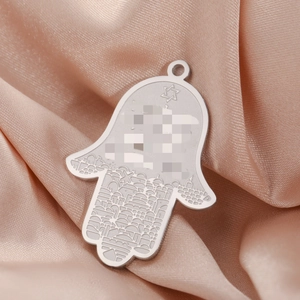 Gravure détaillée sur pendentif Main de Fatma en argent avec paysage urbain et étoile