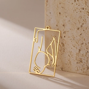 Detailed macro view of gold hollow rectangular pendant with abstract artistic lines