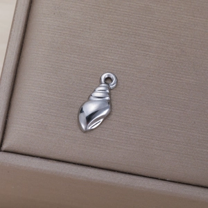 Pendentif coquillage en acier poli sur une boîte à bijoux marron texturée