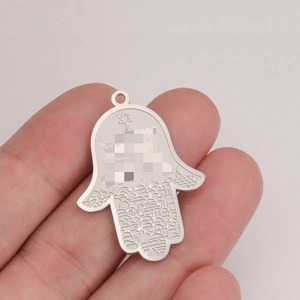 Gros plan sur pendentif Main de Fatima en acier avec gravures de la ville de Jérusalem