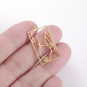 Detailed view of a gold hollow rectangular pendant with an artistic female silhouette