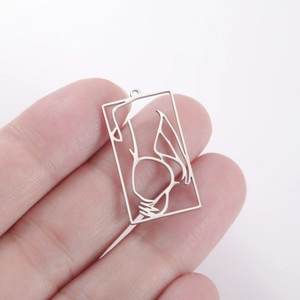 Macro view of rectangular hollow out stainless steel pendant with artistic line art