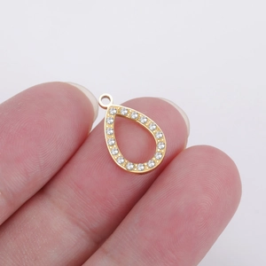 Gold waterdrop pendant with crystals held in hand to show scale for jewelry making