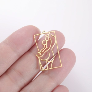 Close-up of golden stainless steel hollow rectangle pendant with artistic female silhouette