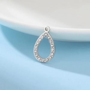Macro shot of silver teardrop hollow pendant with sparkling rhinestones and metal ring