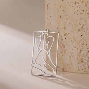 Macro view of a rectangular silver pendant featuring minimalist female silhouette line art