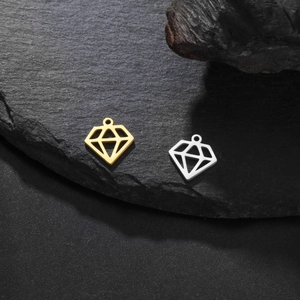 Gros plan de pendentifs évidés en forme de diamant en acier inoxydable doré et argenté