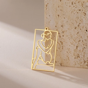 Macro view of a gold hollow-out rectangle pendant with elegant art line portrait
