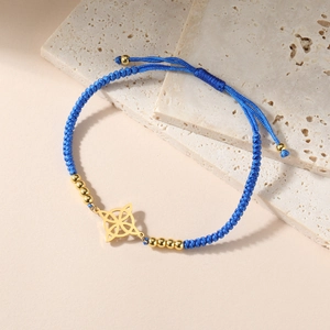 Nahaufnahme des dunkelblauen geflochtenen Armbands mit goldenem keltischem Knoten