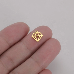 Pendentif losange évidé en acier inoxydable doré posé sur le bout d'un doigt pour échelle