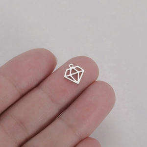Gros plan d'un pendentif diamant argenté sur un doigt montrant sa taille miniature