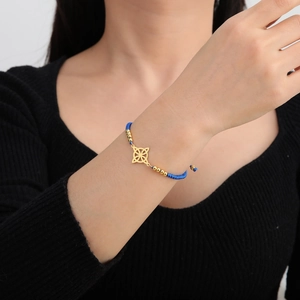 Blaues geflochtenes Armband mit goldenem Keltenknoten-Anhänger und verstellbarer Kordel