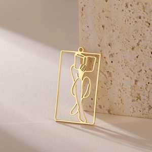 Detailed view of a gold hollowed rectangle pendant with a reading lady silhouette