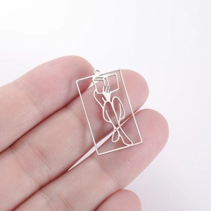 Close-up of minimalist hollow line art portrait pendant held to show size and detail