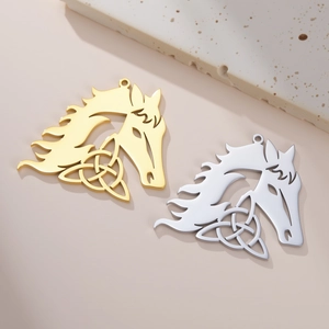 Macro detail of gold and silver hollow Celtic knot horse pendants with smooth metallic finish