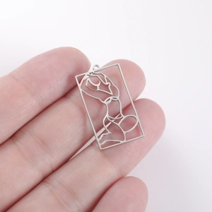 Detailed view of hollow rectangular stainless steel pendant with female silhouette art