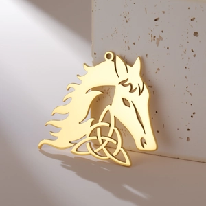Macro detail of 18K gold hollow horse head pendant with Celtic knot on stone base