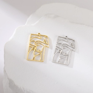 Detailed view of hollow rectangular art pendants in gold and silver abstract designs