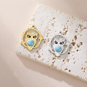 Detailed close-up of gold and silver owl pendants with turquoise stone inlays