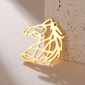 Macro shot of gold-plated hollow horse head pendant with sleek metallic lines