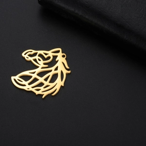 Detailed view of a gold hollowed-out horse head pendant on a black textured surface