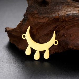 Detailed view of crescent moon pendant with teardrop charms on dark wood surface